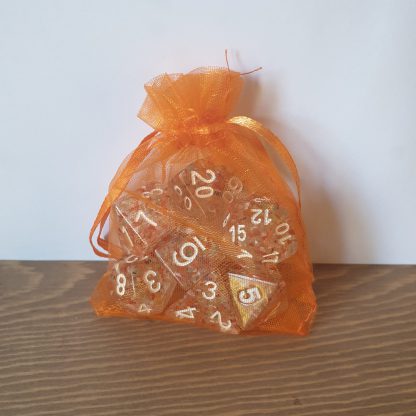 Autumn speckled orange and green polyhedral dungeons and dragons dice set in orange bag